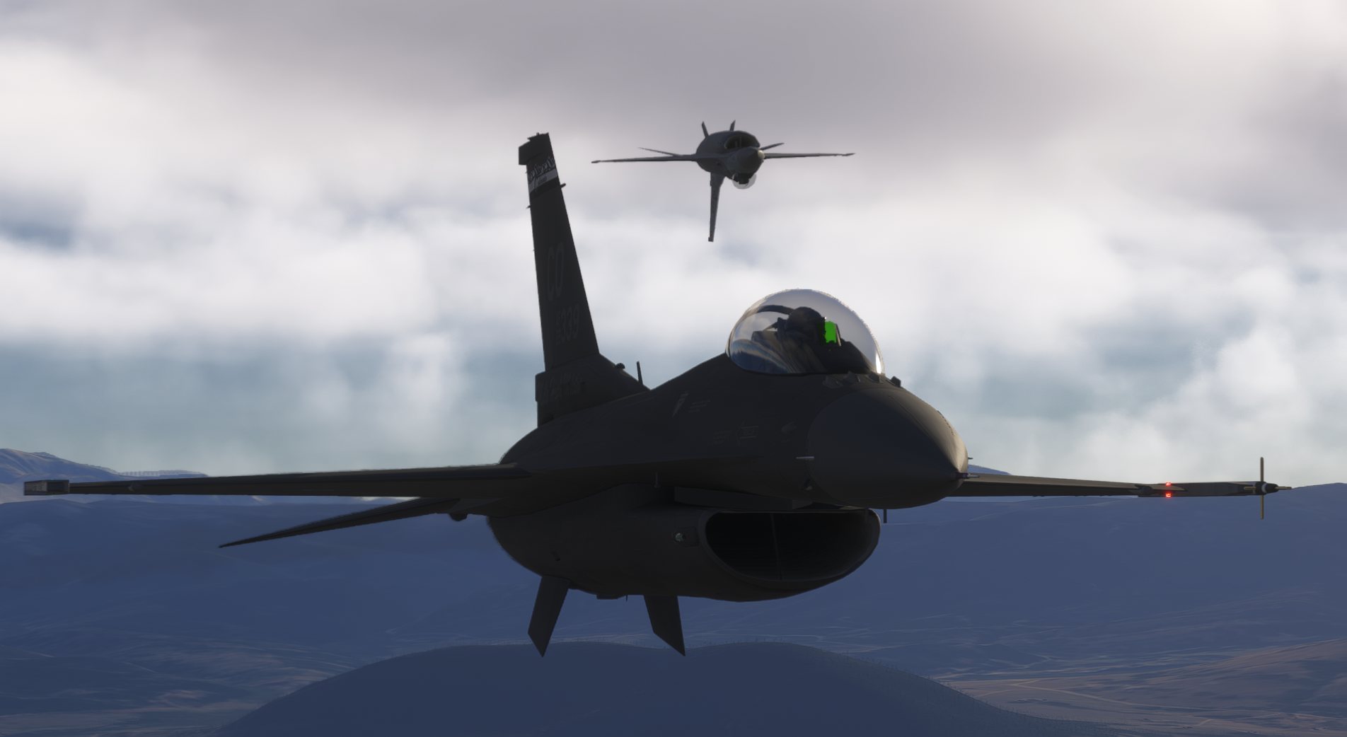 Two virtual F-16 aircraft flying in formation over mountainous terrain